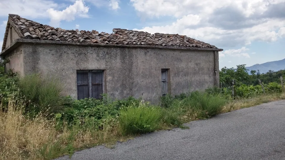A weathered stone building in the hills above the coast